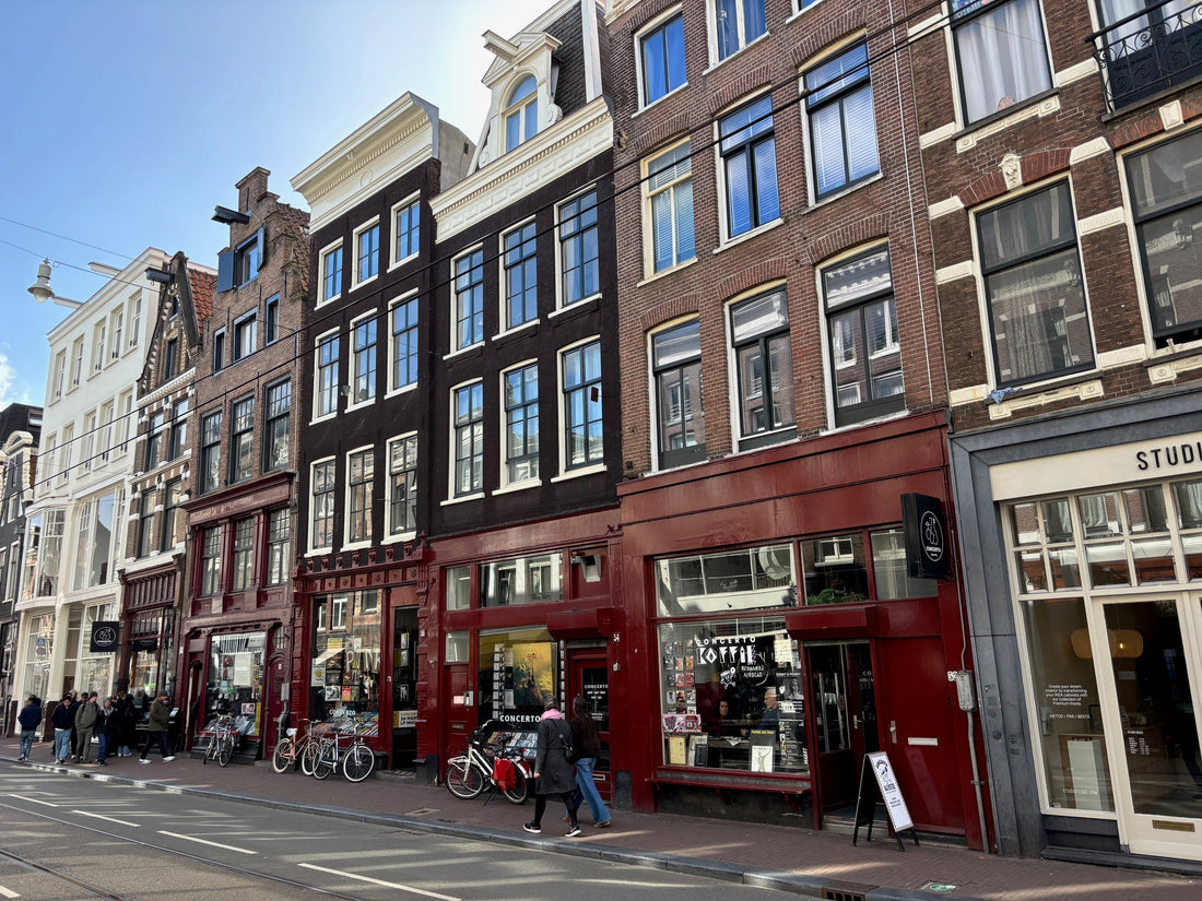 Rode gevel van platenzaak Concerto en Concerto Koffie aan de Utrechtsestraat in Amsterdam, met bezoekers en fietsen voor de winkel
