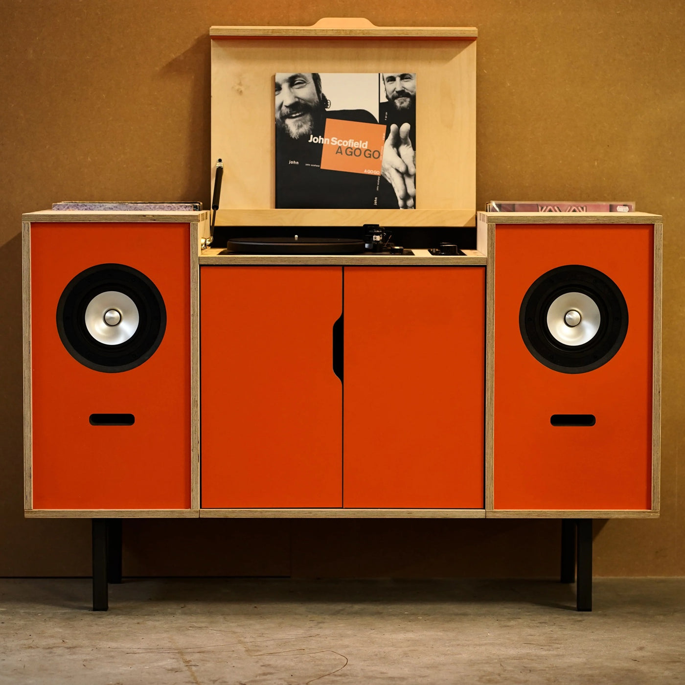 Plyphonic Model B audiomeubel met geïntegreerde platenspeler, luidsprekers en oranje deuren voor vinylopslag